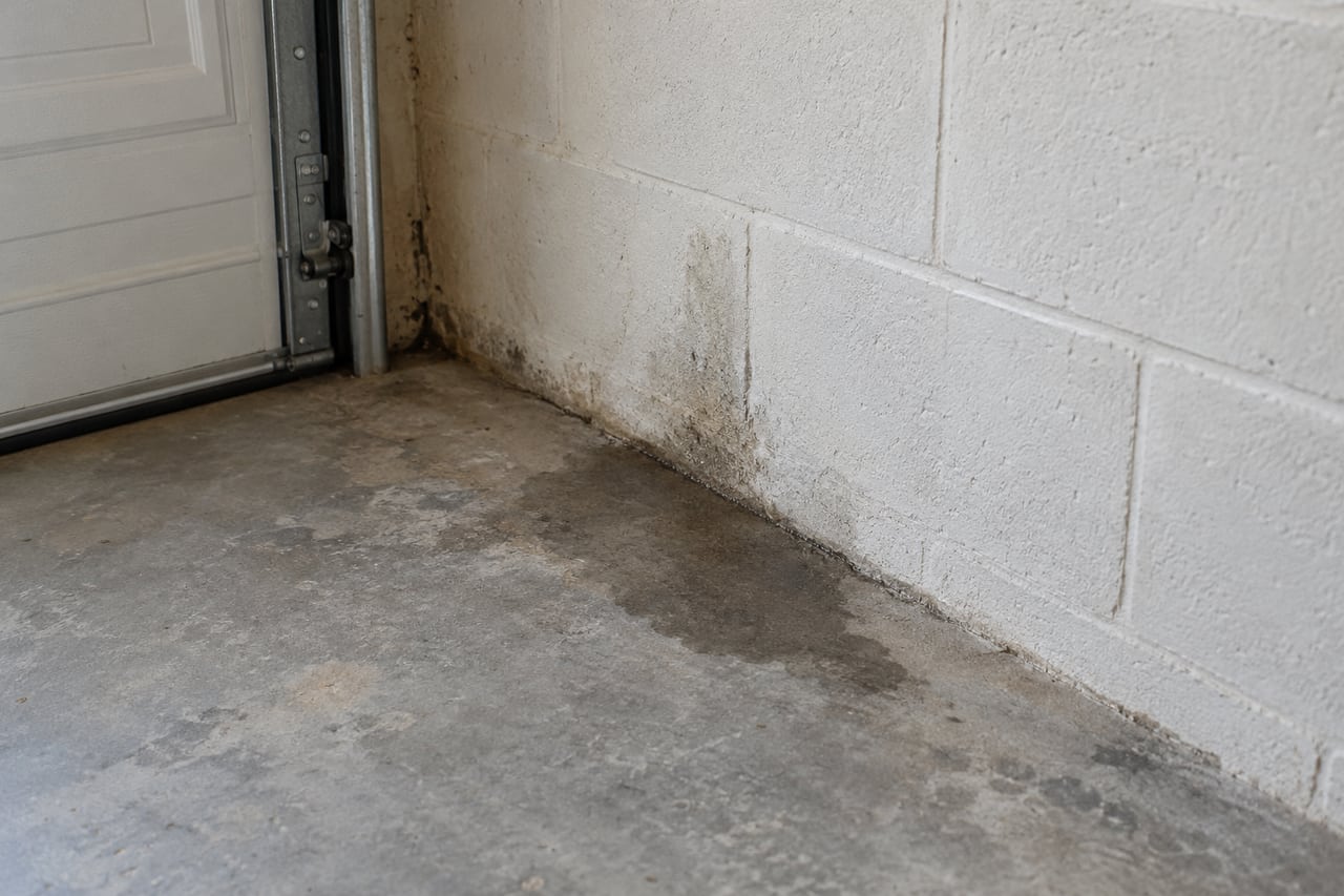 Illustrative damp area at a garage wall and concrete floor